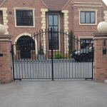 A personalised black, metal gate with two pillars