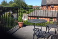 A metal railing balcony overlooking the countryside