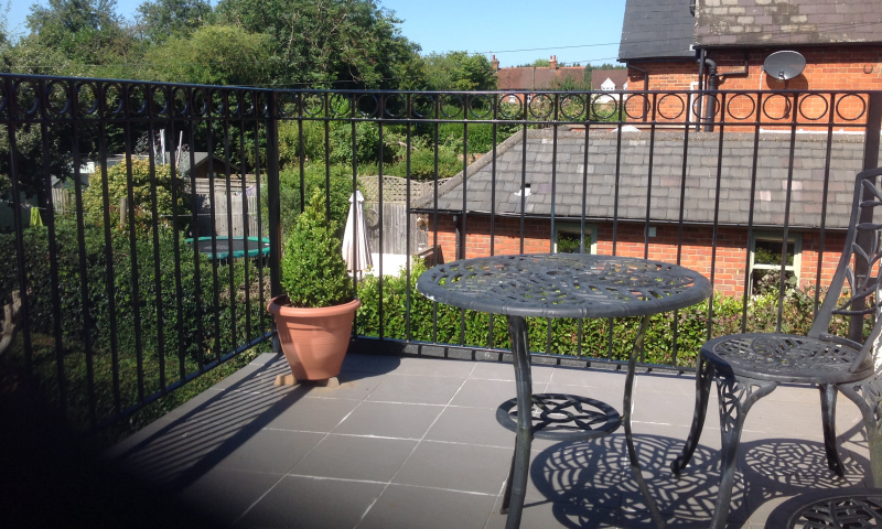 A metal railing balcony overlooking the countryside
