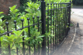 A bespoke metal railing covered in shrubbery