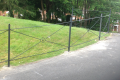 A metal gated railing with a green lawn background