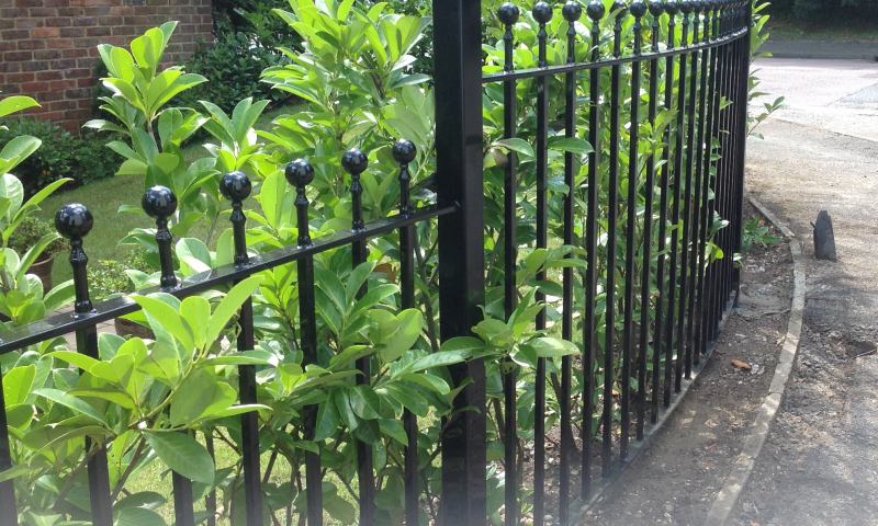 A bespoke metal railing covered in shrubbery