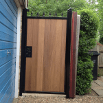 A wooden side gate, adjacent to a garage